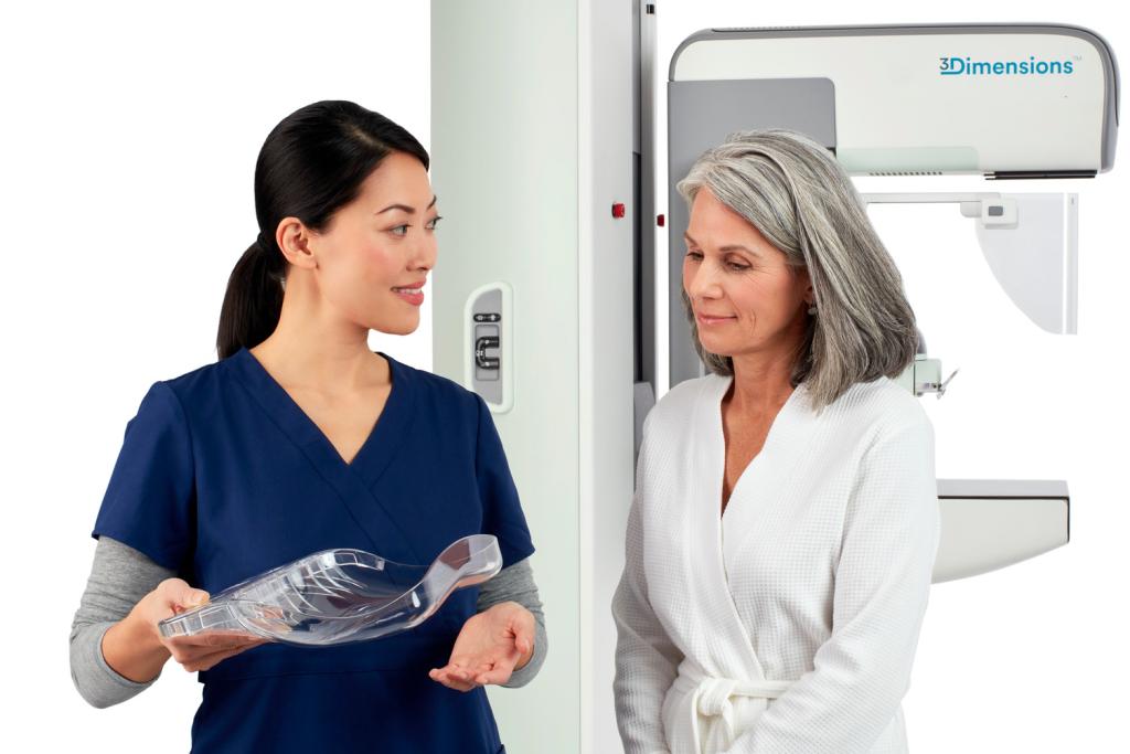 a radiologist is showing the Hologic SmartCurve breast stabilisation accessory to a patient