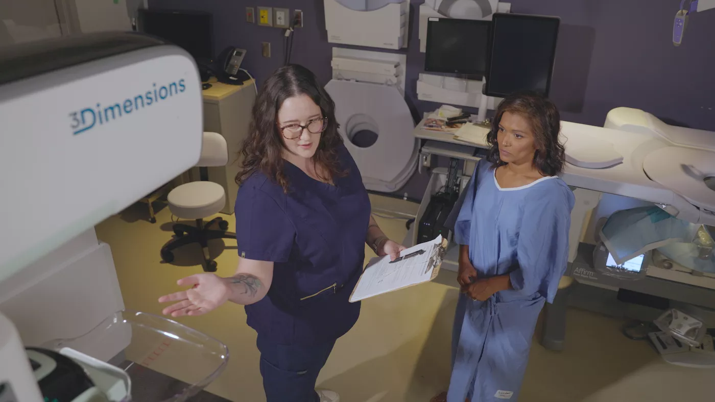 Radiologist speaks to a woman during a mammography exam